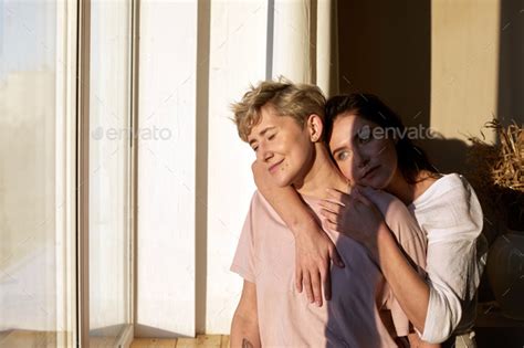 Lesbian Couple Enjoying Sunlight Near Window Stock Photo By Demkat