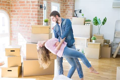 Young Couple Dancing Celebrating Moving To New Apartment Around