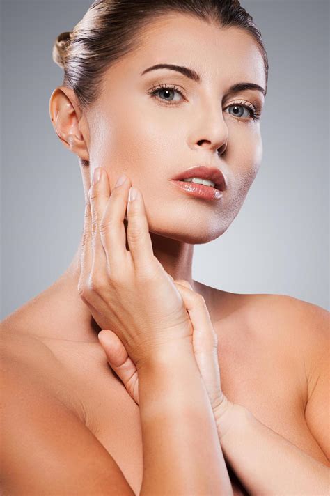 Beautiful And Natural Attractive Mature Woman Looking At Camera And Touching Her Face With Hand