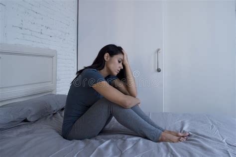 Mujer Latina Triste Y Deprimida Hermosa Que Se Sienta En La Cama En Casa F Foto De Archivo