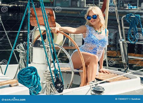Femme Blonde Dans La Robe Blanche Et Le Maillot De Bain Transparents Se Tenant Sur Le Yacht