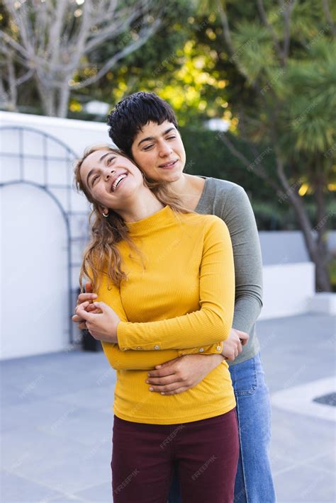 Premium Photo Happy Biracial Lesbian Couple Standing On Garden Terrace Embracing And Smiling