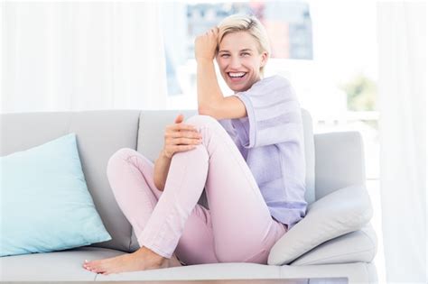 Premium Photo Pretty Blonde Woman Sitting On The Couch And Smiling At