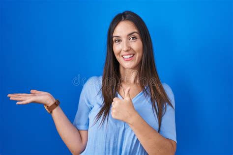 Jeune Brunette Debout Sur Fond Bleu Montrant La Main De La Paume Et Faisant Un Geste Ok Avec Les