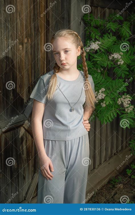 Portrait Of A Beautiful Girl Of 14 Years Old With Long Blonde Hair Girl With Braids Seriously
