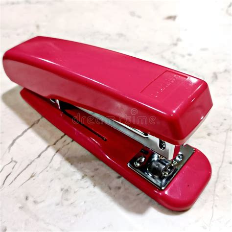 A Large Red Stapler On A Marble Table Stock Image Image Of Objects