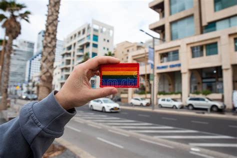 Lgbt Rainbow Gay Pride Flag In Hand On City Building Background Concept For Lgbtq Equality