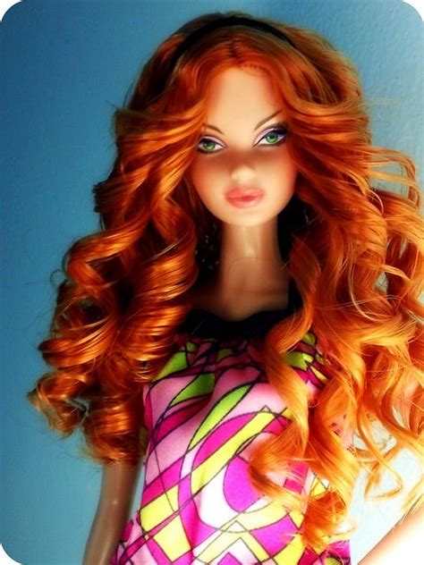 A Close Up Of A Doll With Red Hair And Green Eyes Wearing A Colorful Dress