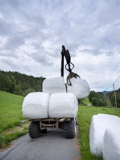 Cargando Rollos De Pasto Blanco En La Carretera De Campo En Noruega