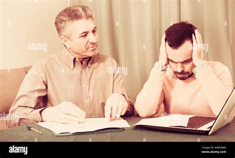 Mature Father And Son Arguing And Discussing Important Documents At Home Stock Photo Alamy