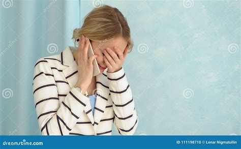 Young Alarmed Woman In A Striped Jacket Talking On The Phone Stock