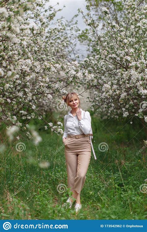 Beautiful Young Blonde Woman In White Shirt With Backpack Posing Under