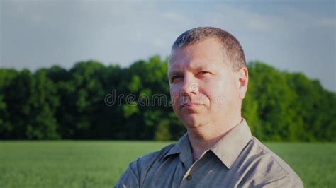 A Man Is Standing In A Field Looking Into The Distance Portrait Of A