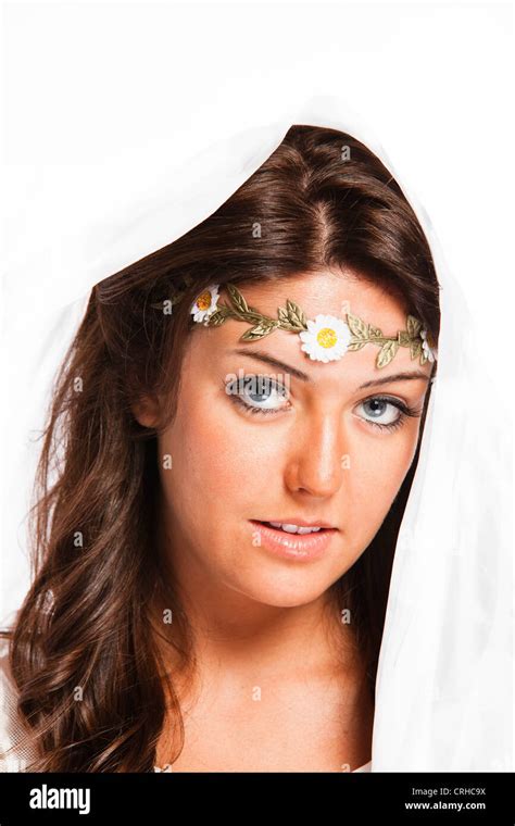 An Eighteen Year Old Brunette Woman In A White Sun Dress With A Flowered Headband In Studio Over