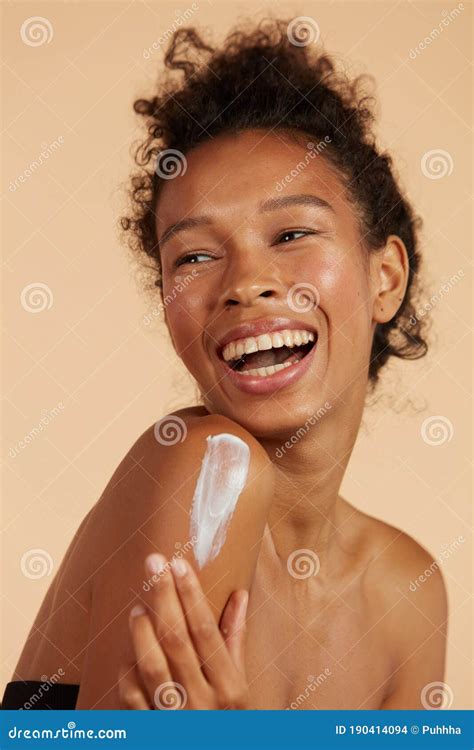 Body Skin Care Smiling Black Woman Applying Body Cream Portrait Stock