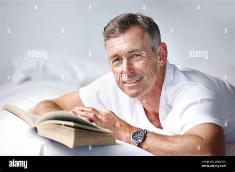 Simply Cant Put It Down Portrait Of A Mature Man Reading A Book In Bed