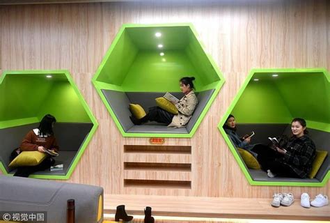 Some People Are Sitting And Reading Books In The Green Cubes On The