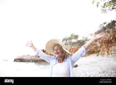 Happy Mature Woman Wearing Straw Hat On The Beach Stock Photo Alamy