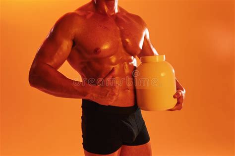 Man Bodybuilder Boxer With Naked Torso With Abs Holding A Can Of Muscle Growth Pills Steroids