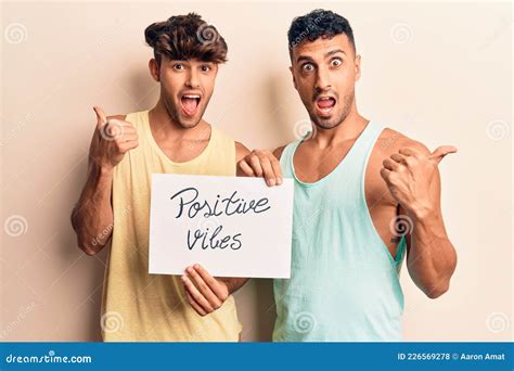 Joven Pareja Gay Sostiene Una Pancarta Con Vibraciones Positivas Apuntando El Pulgar Hacia El
