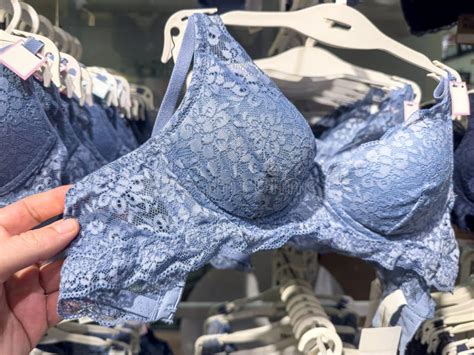 Woman Chooses Blue Lace Bra On Rack In Lingerie Store Female Fashion Underwear Stock Photo