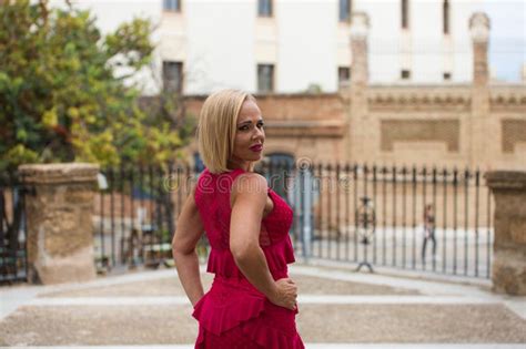 Mature Blonde And Beautiful Woman Wears An Elegant Black Dress And Poses For The Pictures Happy