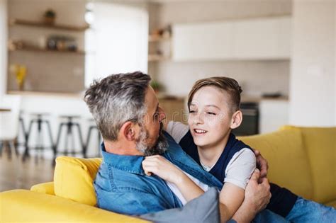 Mature Father With Small Son Sitting On Sofa Indoors Resting Stock Image Image Of Comforting
