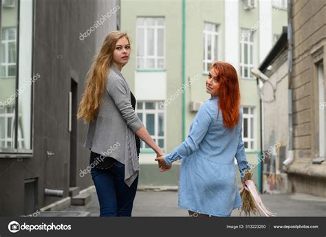 Same Sex Relationships Happy Lesbian Couple Walking Down The Street Holding Hands The Backs Of