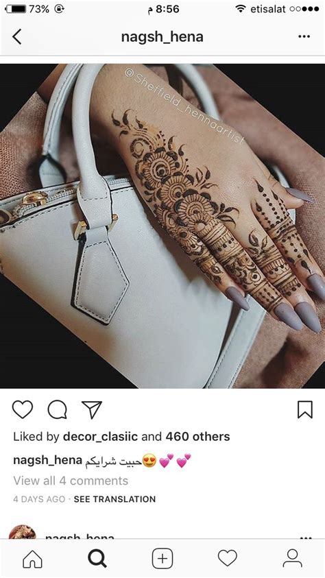 A Woman S Hand With Henna On It And A Purse In The Background