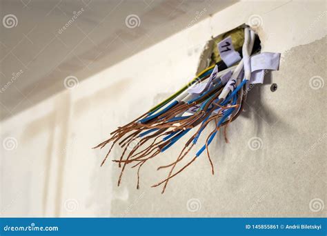 Electrical Exposed Connected Wires Protruding From Socket On White Wall