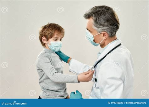 Docteur Mature Professionnel Et Petit Patient Dans Les Masques De Protection Pédiatre Mâle Dans
