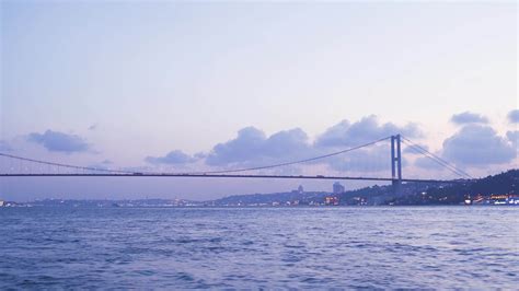 Bridge and city at night. General view of the bridge with the city from the sea at night. Cars ...