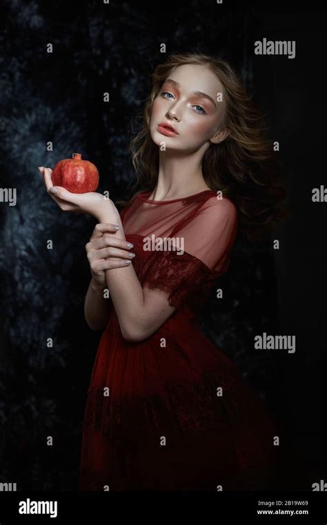 Belle fille blonde avec des fruits à la grenade dans ses mains Portrait printanier d une fille