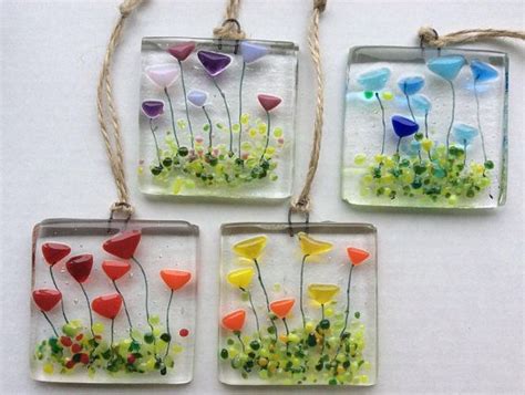 Four Square Glass Ornaments With Flowers In Them Hanging From Twine