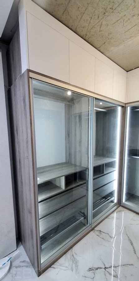 Просторная и функциональная гардеробная со шкафами-купе и стеной с ...