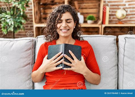 Joven Latina Sonriendo Confiada Abrazando La Biblia En Casa Foto De Archivo Imagen De