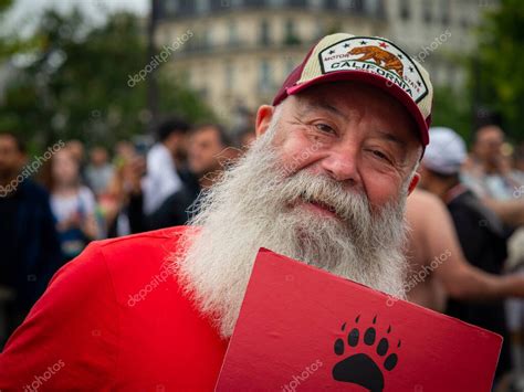 Un hombre caucásico mayor con una larga barba en el orgullo gay de París 2022 mirando a la