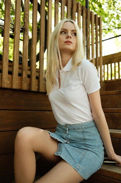 Premium Photo Portrait Of Blonde Woman Sitting On Railing