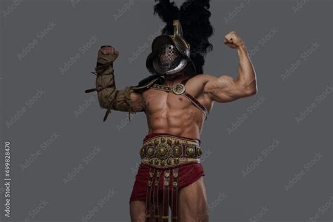 Shot Of Handsome Greek Warrior With Nude Muscular Body Showing His Strength Against Grey