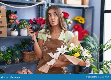 Jeune Brunette Travaillant Dans Un Fleuriste Tenant Un Appareil Photo En Train De Faire Le