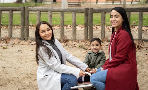 Two Lesbian Couple And Their Son Having Fun In A Playground Stock Photo Image Of Green