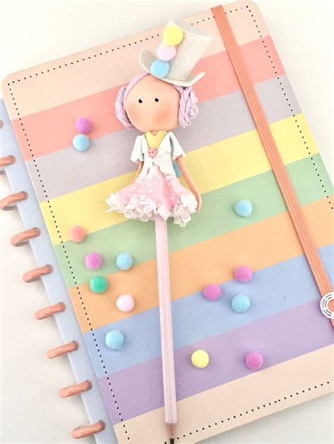 A Colorful Notebook With A Paper Doll On The Cover And Colored Pencils