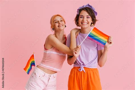 Excited Lesbian Couple Hugging While Posing With Rainbow Flags Stock Bilde Adobe Stock