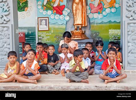 children and teacher praying in the Weherahena temple of Matara, Sri ...