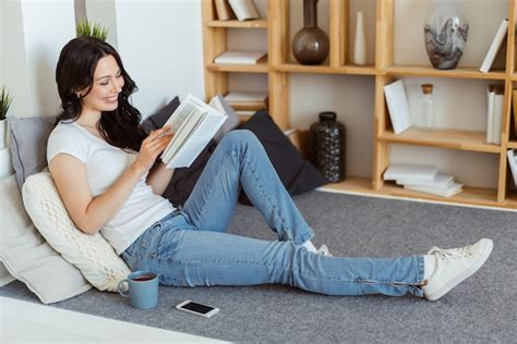 Premium Photo Cute Young Woman Reading A Book While Sitting At Home