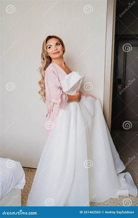 A Blonde Bride In Pink Peignoir Keeps A White Wedding Dress Stock Image Image Of Clothes
