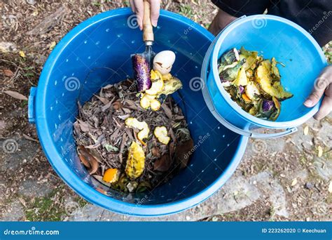 Person Adding Kitchen Organic Green Waste Into Bin To Be Turned Into