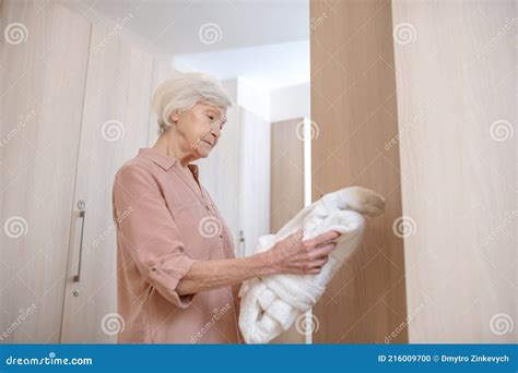 Gray Haired Mature Woman In A Changing Room In Spa Center Holding A