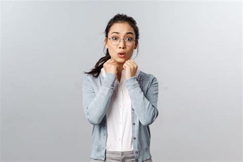 Timid And Shy Asian Girl In Glasses Brunette Hair Combed Hold Hands Near Chest Gasping And