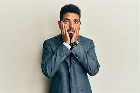 Handsome Hispanic Man With Beard Wearing Business Suit And Tie Tired